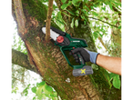 Man using a Parkside 20 V cordless branch cutter to trim a tree branch.