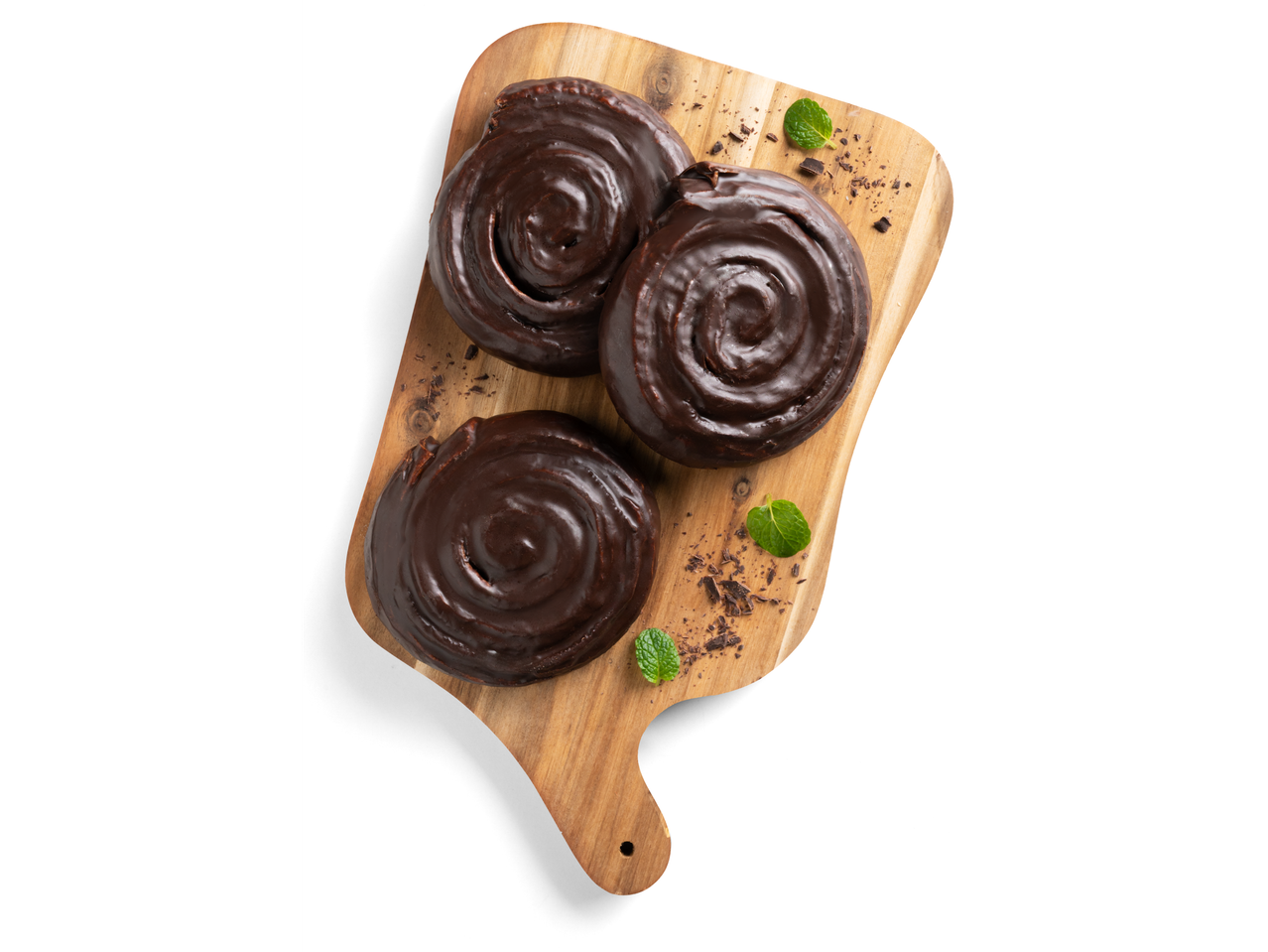 Három csokoládéval bevont kakaós csiga egy fa deszkán, mentával és csokoládéforgáccsal.