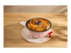 Bundt cake in a pink baking pan on a marble board with raspberries and almonds.