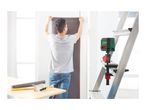 A laser level attached to a ladder, projecting a red line onto a wall where a person is hanging wallpaper.