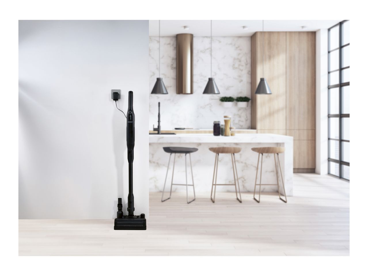 Cordless stick vacuum cleaner charging on its stand in a modern kitchen.