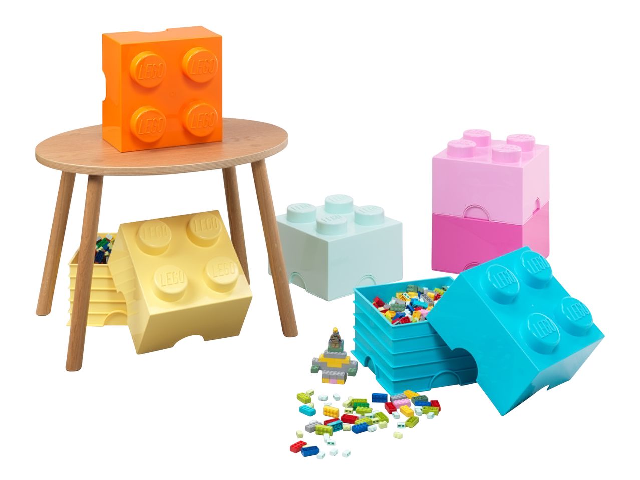 Bunte Baustein-Aufbewahrungsboxen und lose Bausteine auf einem Holztisch und dem Boden.