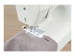 Sewing machine with a buttonhole foot attachment stitching a buttonhole on grey fabric
