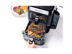 Salter air fryer with steak and fries, with a plate of steak and fries in the background.