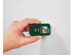 Mão segurando um medidor de humidade de madeira contra uma parede branca texturizada, exibindo 28°C e 8,0% de humidade.
