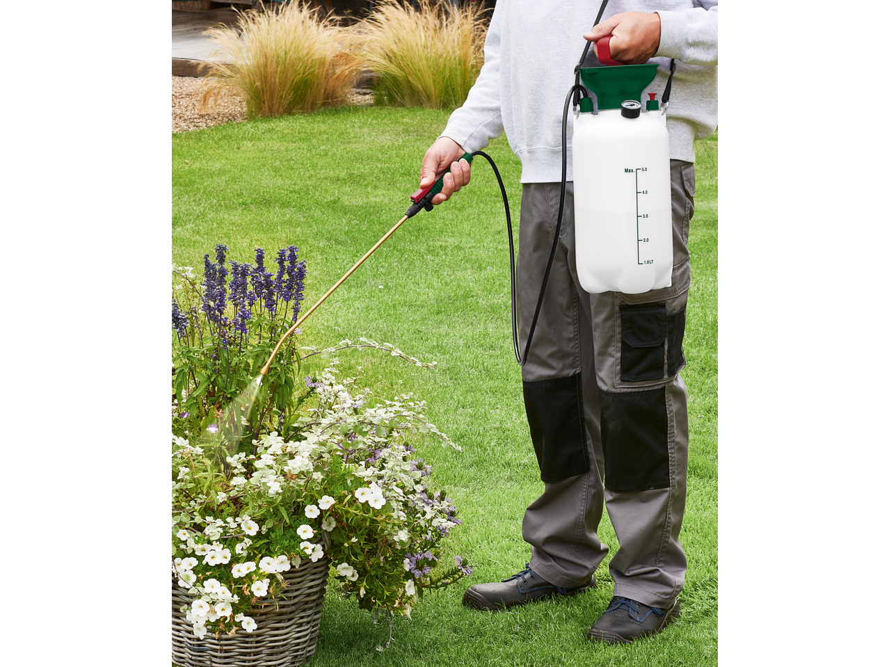 Parkside® Garden Pressure Sprayer in use, watering flowers in a garden.