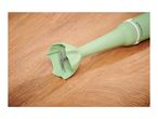 Light green immersion blender with a silver blade on a wooden surface.