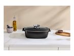 Black rectangular roasting pan with a glass lid on a kitchen countertop