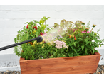 PARKSIDE cordless pressure washer watering plants in a wooden garden planter.