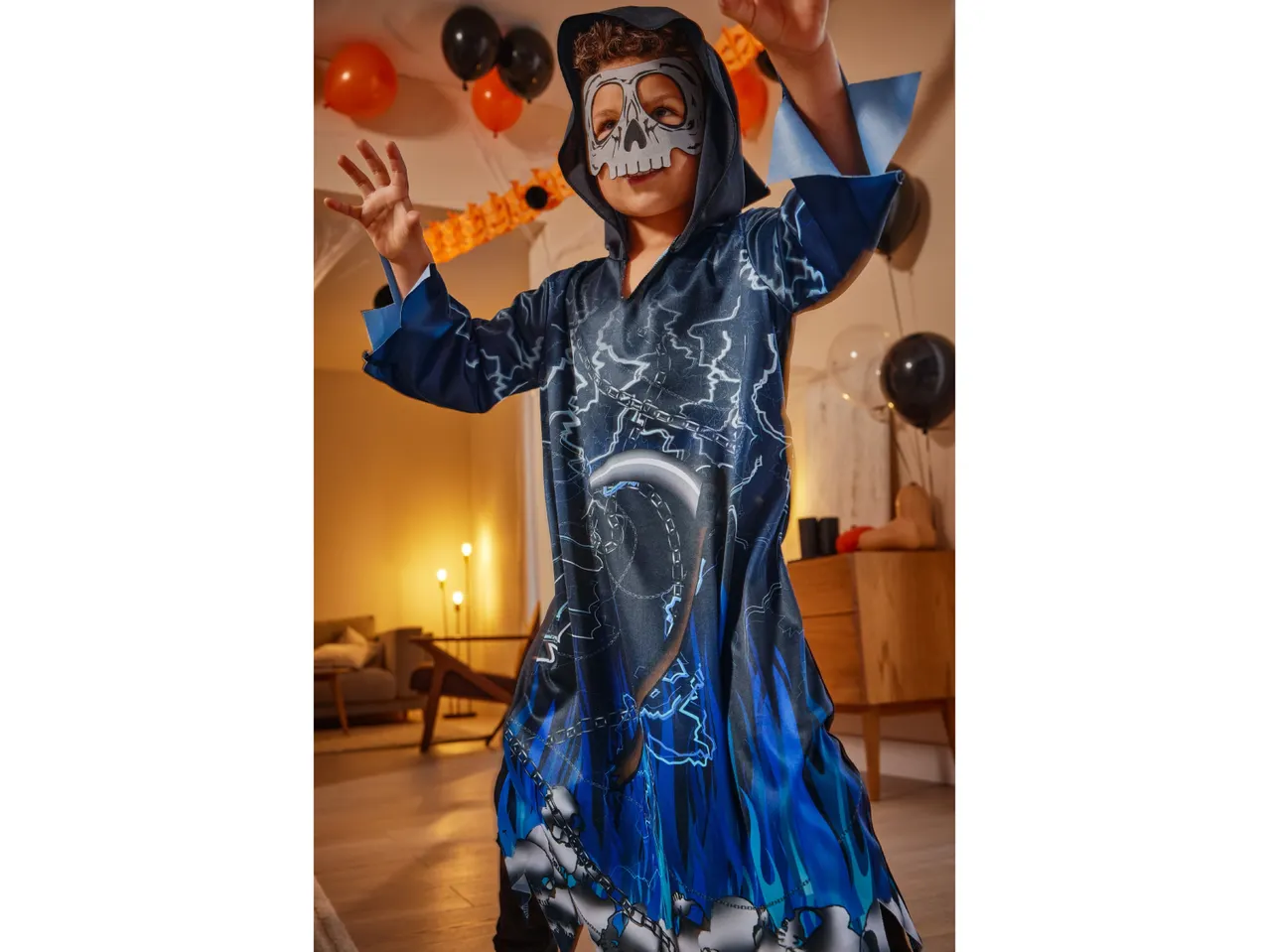 A boy in a blue and black ghost costume with a skull mask, celebrating Halloween.