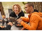 Friends enjoy a meal outdoors, wearing comfortable hoodies and using a Camping Tableware Set.