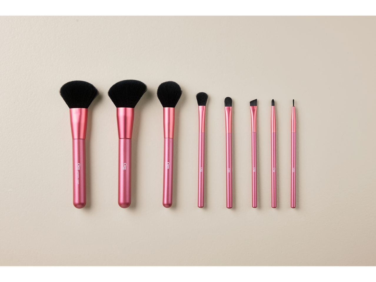 Ensemble de pinceaux de maquillage Cien roses sur fond beige.