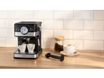 Espressor negru cu două cești, cafea măcinată și o ceașcă de cappuccino pe un blat de lemn.