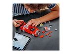 Child building a red toy car with building blocks, following instructions on a tablet.