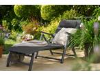 LIVARNO HOME aluminijumska ležaljka sa jastukom i ćebetom u cvetnom vrtu.