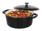 Black cast iron pot with a lid, filled with colorful vegetables and meat
