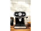 Black SilverCrest espresso machine on a wooden counter with white tiled background.