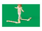 Toddler balancing on a wooden balance beam with colorful steps on a green background.