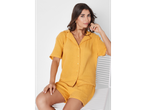 Mulher com um conjunto de pijama de algodão amarelo.