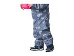 Child in blue rain overalls with construction vehicle print, holding a pink cup.