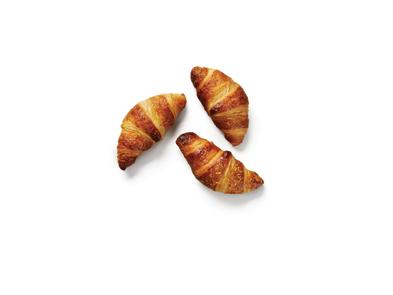 Trīs zeltaini kruasāni ar cukura drumstalām uz melna fona.