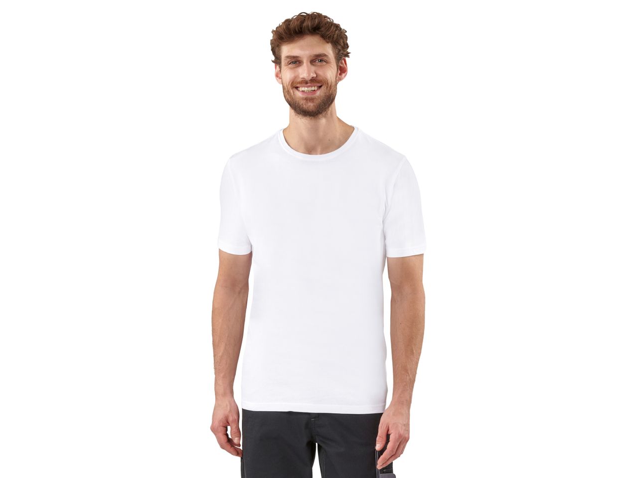 A man smiles while wearing a plain white t-shirt and dark gray cargo shorts.