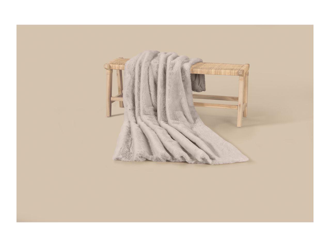 Soft faux fur blanket draped over a wooden bench