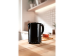 A black SILVERCREST® 2200W kettle on a wooden kitchen counter with a cup of tea.