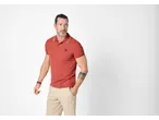 Man wearing a red Esmara polo shirt and beige trousers.