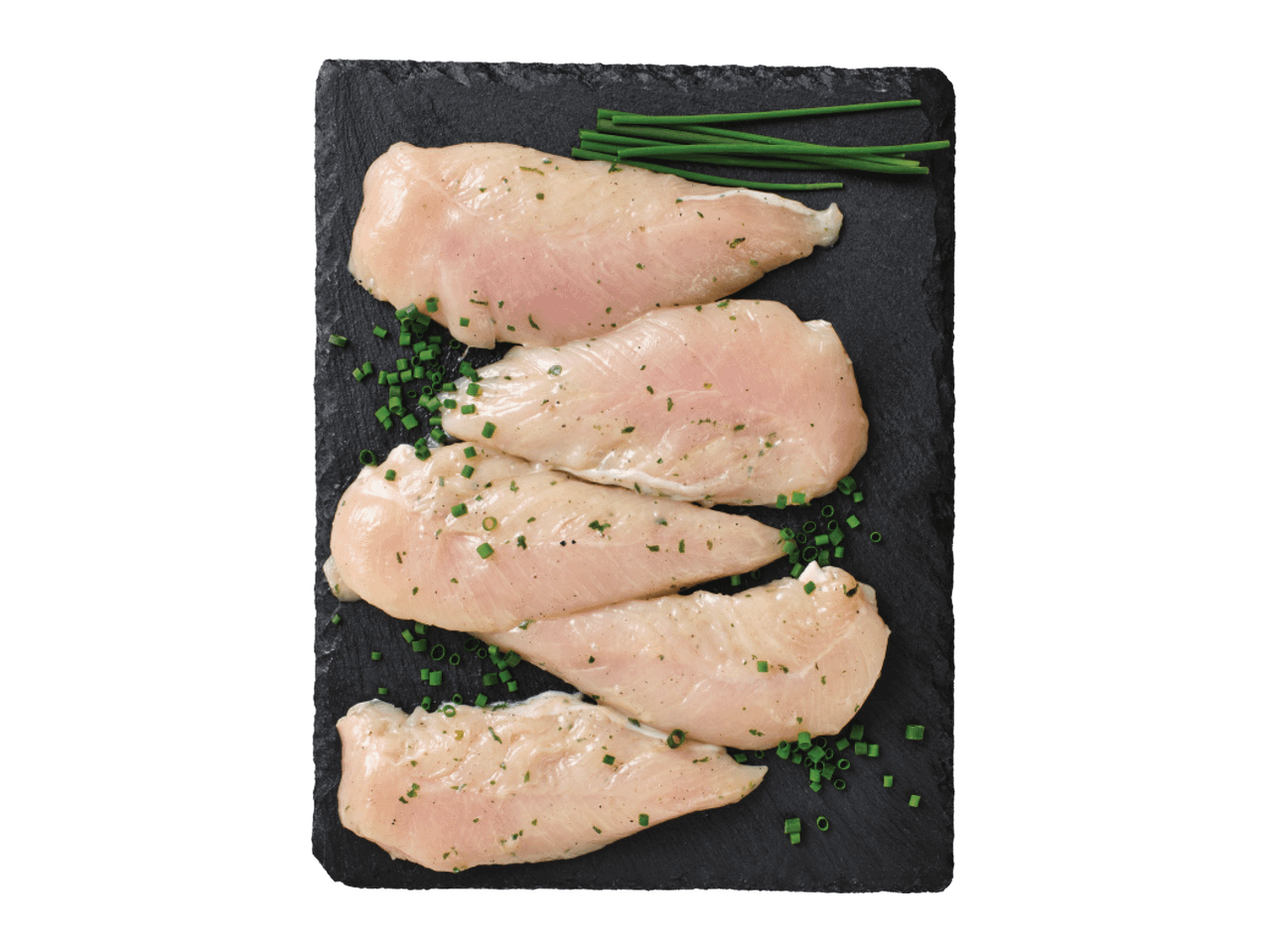 Jēla vistas fileja, garšvielām bagāta ar zaļumiem, uz melna akmens dēļa.