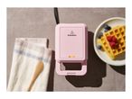 Pink SilverCrest waffle maker with waffles and berries on a plate.