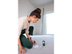 A woman uses a PARKSIDE® Laser Distance Measurer in a room under construction.