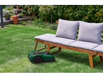 PARKSIDE smart robotic lawnmower in the garden with a wooden bench.