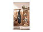 Bathroom with wooden shelving unit, towels, bath brush, and bath mat.