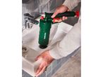 A person using a green drain blaster to clear a sink in a bathroom.