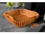 Forros quadrados de papel castanho para fritadeira de ar numa superfície cinzenta.