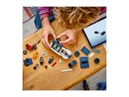 Child building a toy police car and motorcycle with building blocks, following instructions on a tablet.
