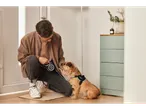 Muškarac stavlja Superdog povodac svom psu.