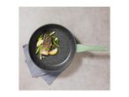 Frying pan with salmon, asparagus, and lemon on a grey background