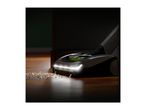 A cordless vacuum cleaner with LED headlights cleaning dirt on a wooden floor.