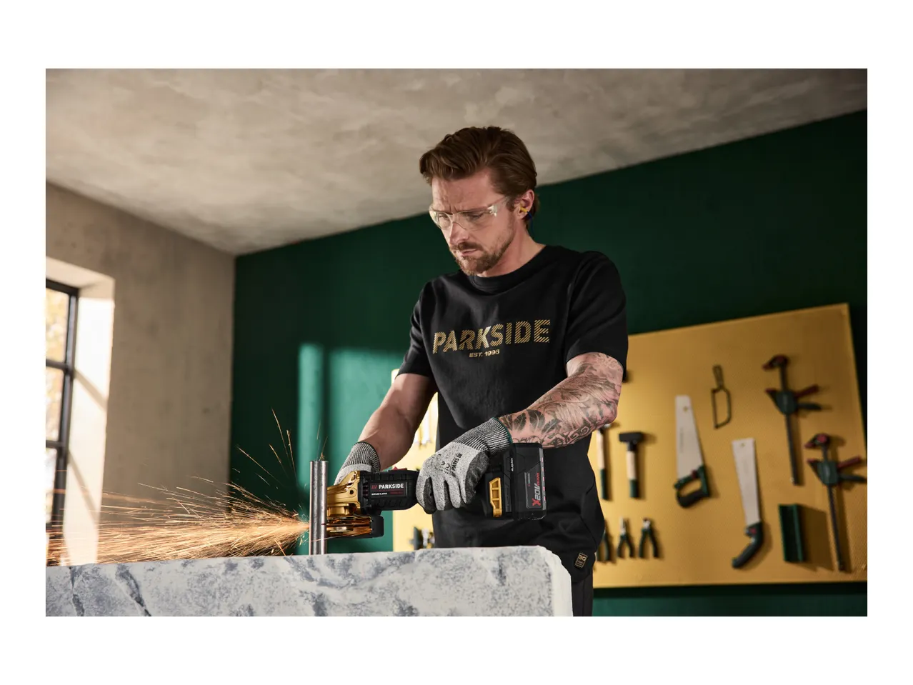 Man using an angle grinder, sparks flying, in a workshop setting.