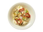 Risotto with grilled zucchini, red peppers, and fresh basil in a light-colored bowl.