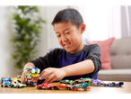 Uma criança brinca com vários carrinhos Hot Wheels, empilhando alguns.
