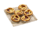 Sept Pastel de Nata sur un tissu beige.