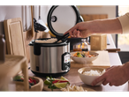 SILVERCREST® Reiskocher a servir arroz com uma refeição num ambiente de cozinha.