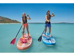 Two people paddleboarding on inflatable SUP boards in turquoise water.
