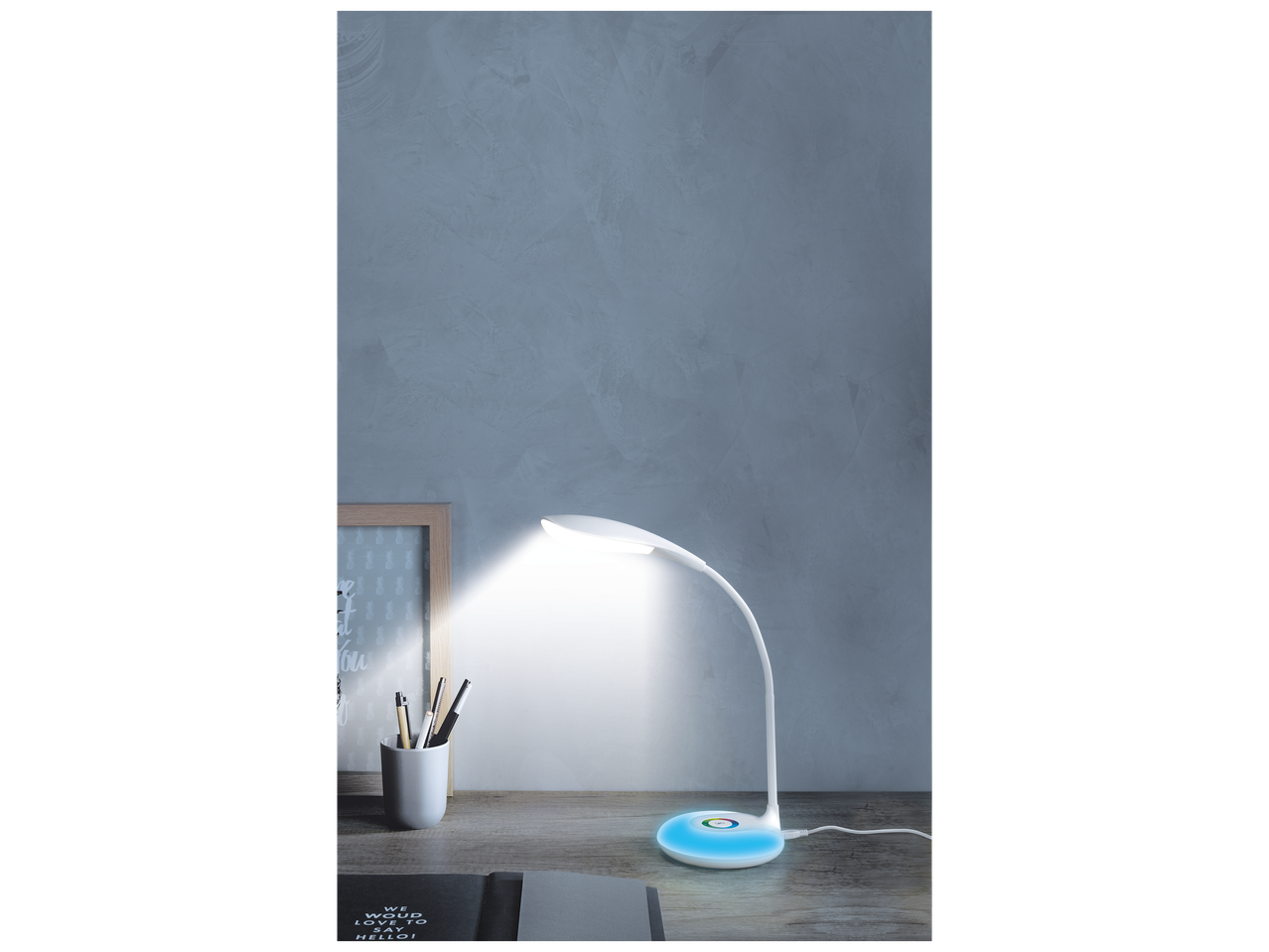 Lampe de bureau LED blanche avec base lumineuse colorée sur un bureau en bois.