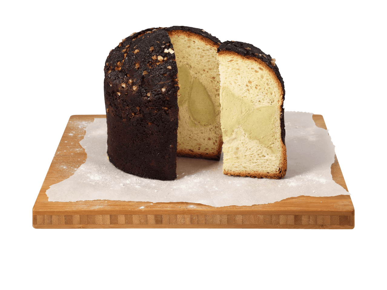 Pistazien-Panettone auf einem Holzschneidebrett mit Backpapier und Puderzucker.