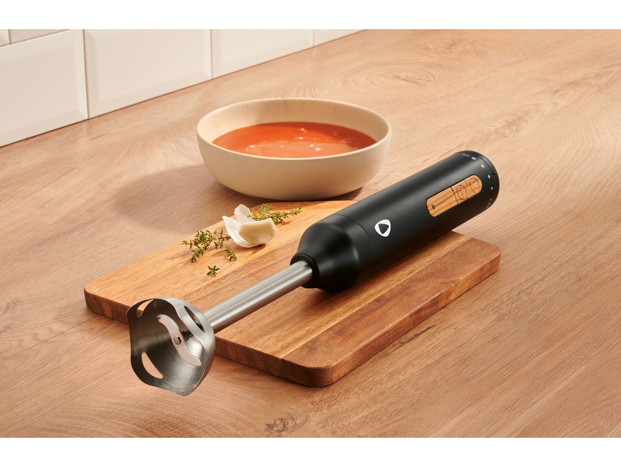 SILVERCREST® 600W Hand Blender Set on a wooden board next to a bowl of soup.