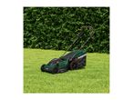 A green lawnmower with a grass collection bag on a lawn in front of a green hedge.
